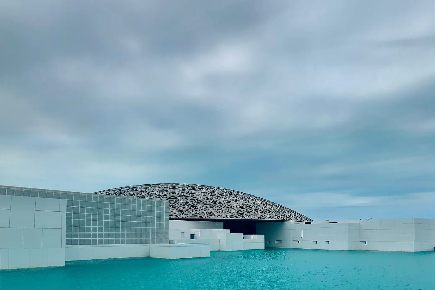 Louvre Abu Dhabin teräskupoli ja turkoosi vesi