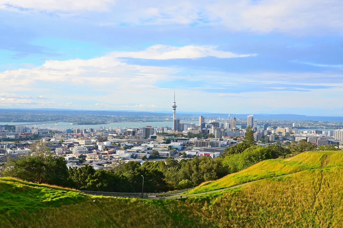 Aucklandin siluetti ja Sky Tower vihreiden kukkuloiden takaa