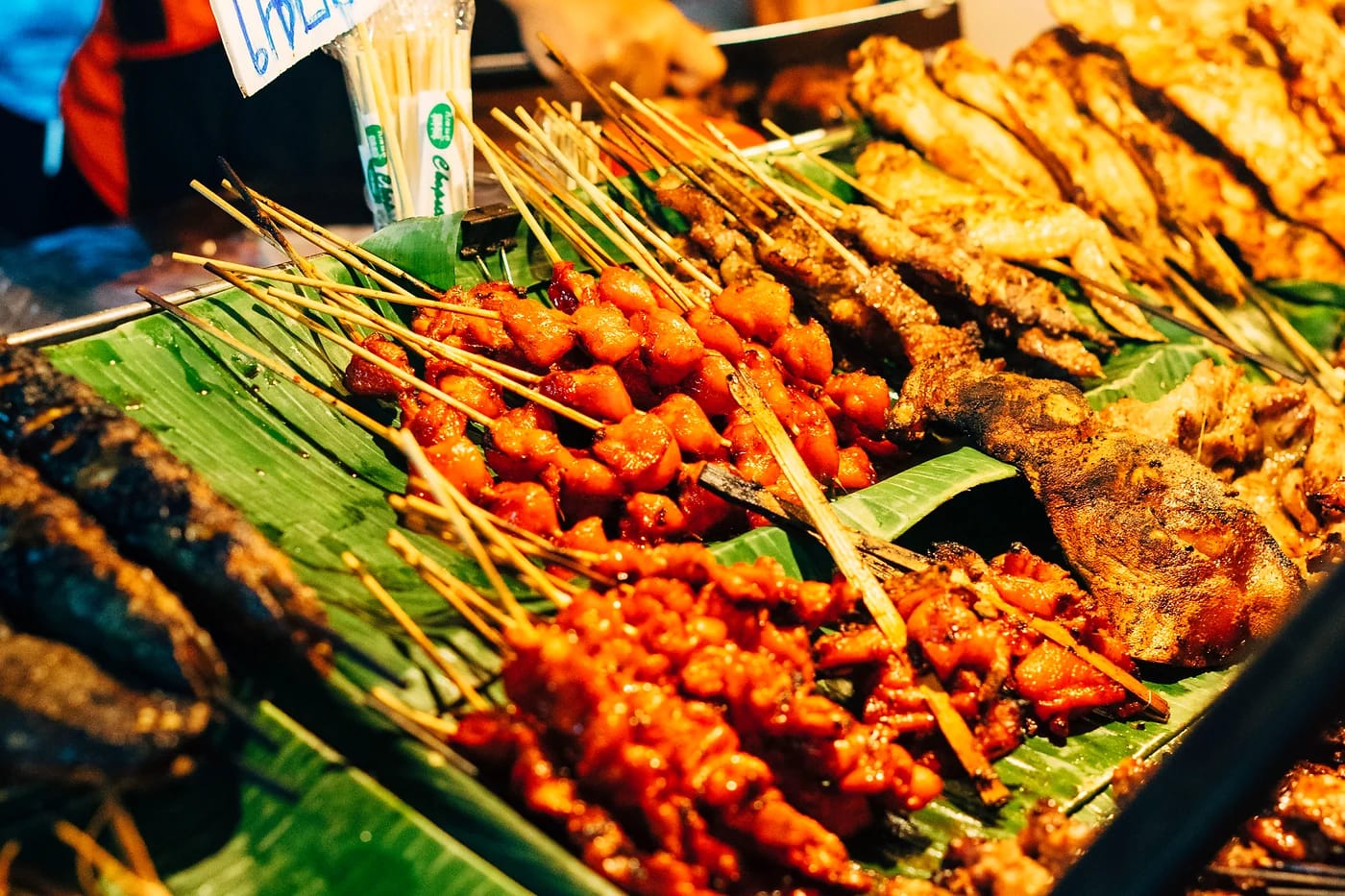 Thaimaalaisia grillivartaita katukojulla Chiang Maissa