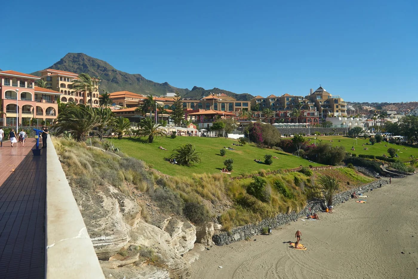 Costa Adejen rantahotelleja ja tummaa hiekkarantaa vuorten juurella