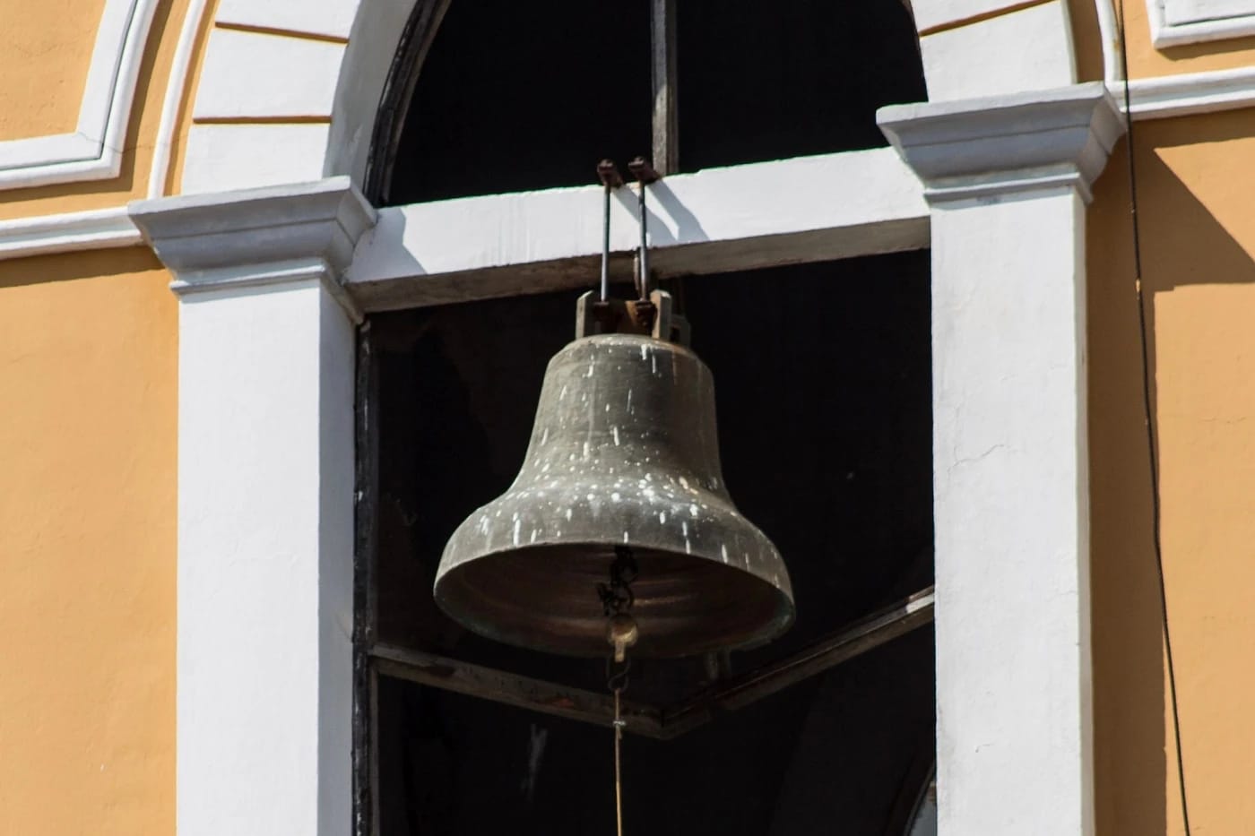 Kirkonkello siirtomaakirkon kaari-ikkunassa