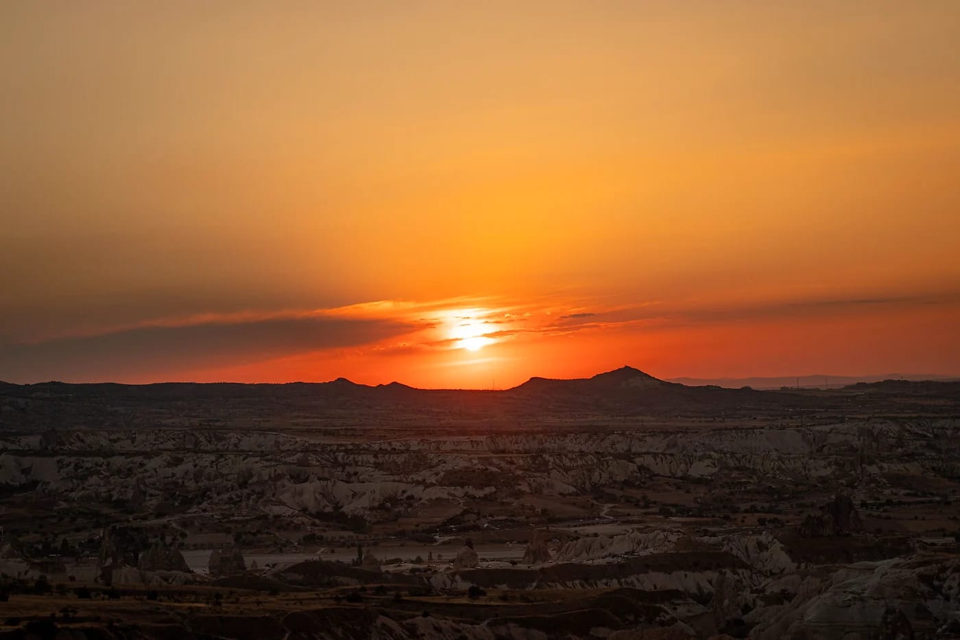 Auringonlasku Kappadokian kalliomuodostelmien yllä Ürgüpissä