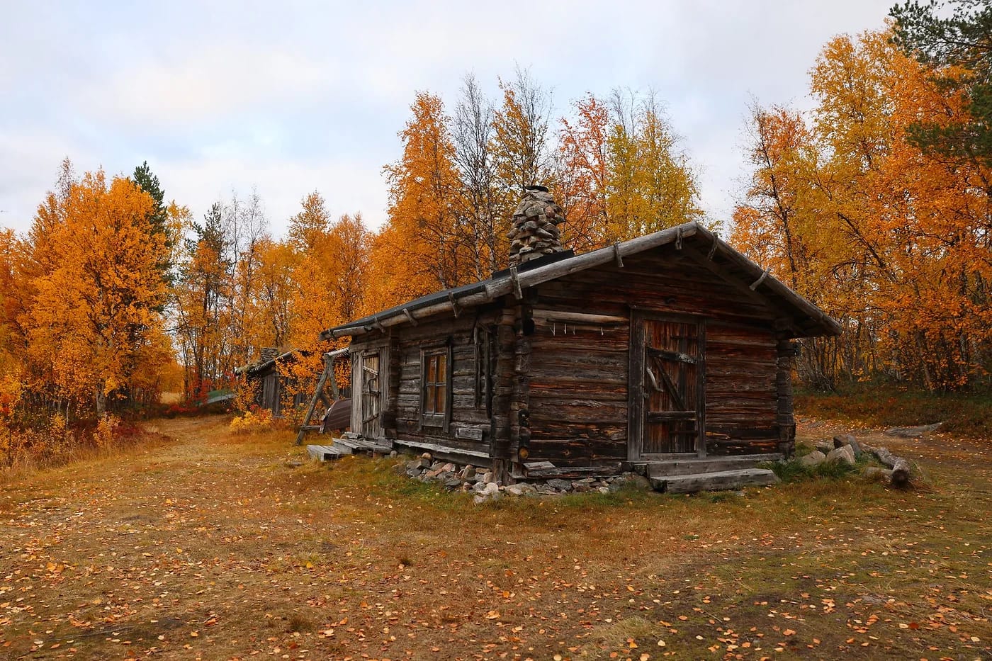 Erämaan hirsimökki ruskan keskellä