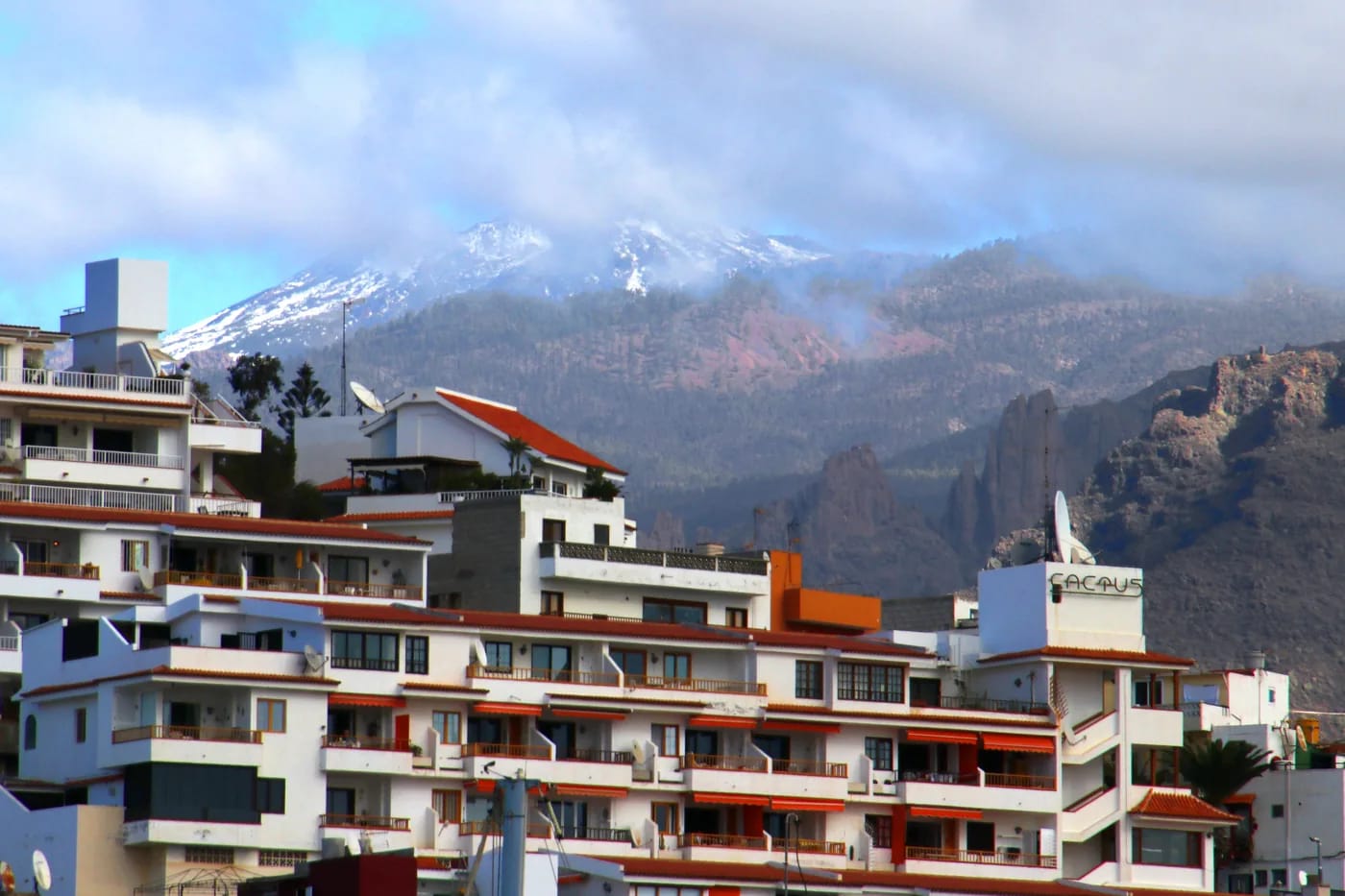 Los Cristianosin lomahotelleja, taustalla lumihuippuinen Teide