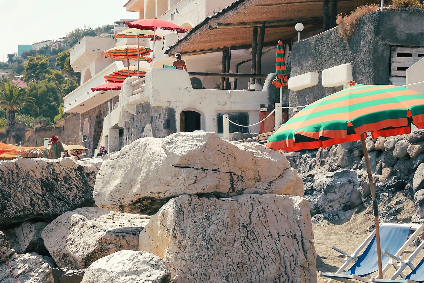 Rantaklubin aurinkovarjoja ja lohkareita Positanossa