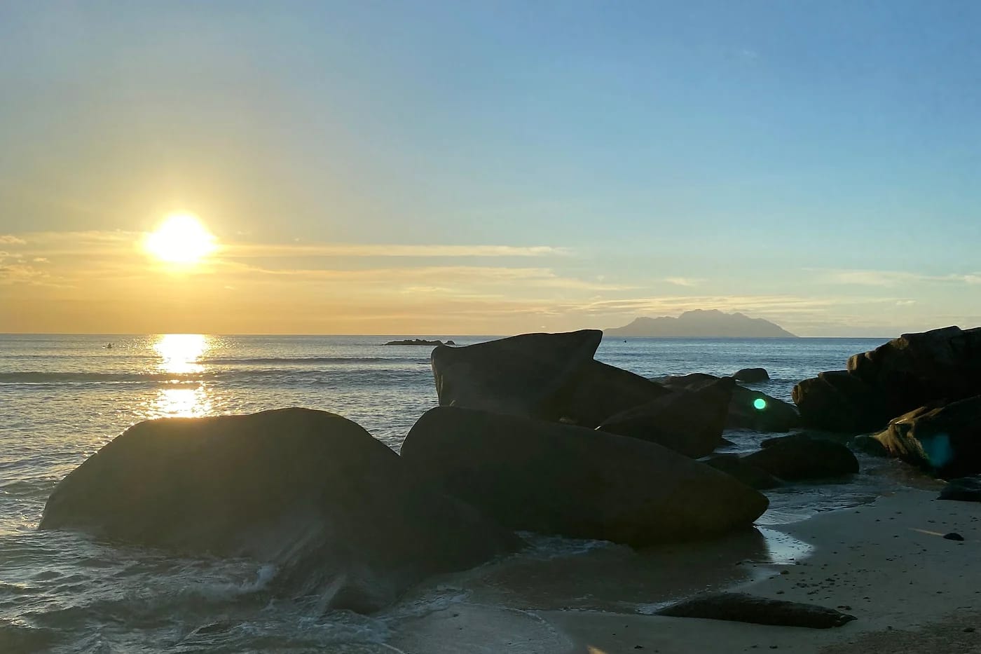 Auringonnousu graniittikallioiden yllä Praslinin rannalla
