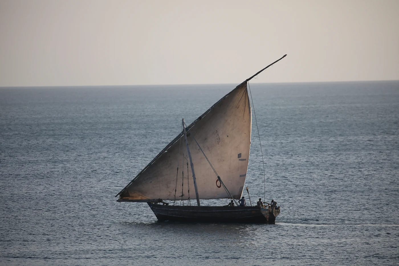 Perinteinen dhow-purjevene auringonlaskussa Sansibarissa