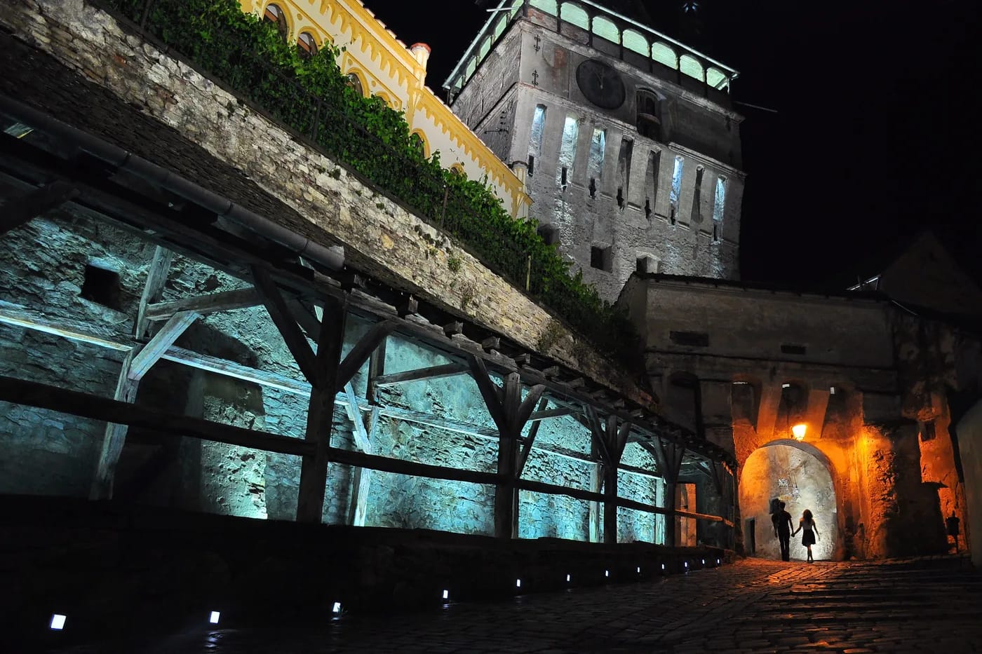 Valaistu kivikuja ja portti Sighișoaran citadelissa illalla