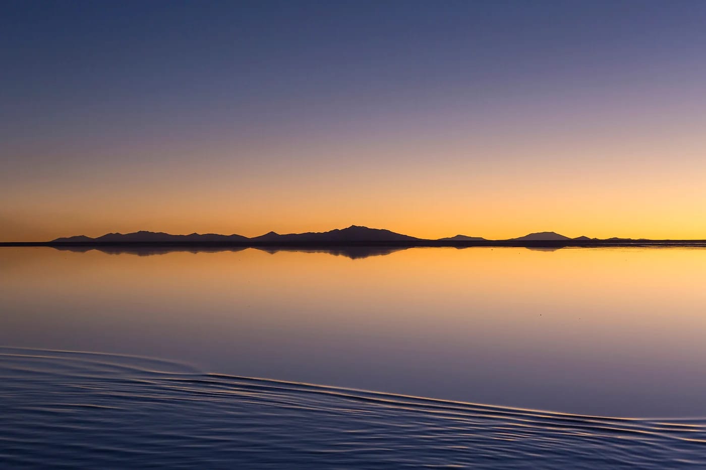 Vuorten heijastus suolapeilistä auringonnousussa Uyunissa