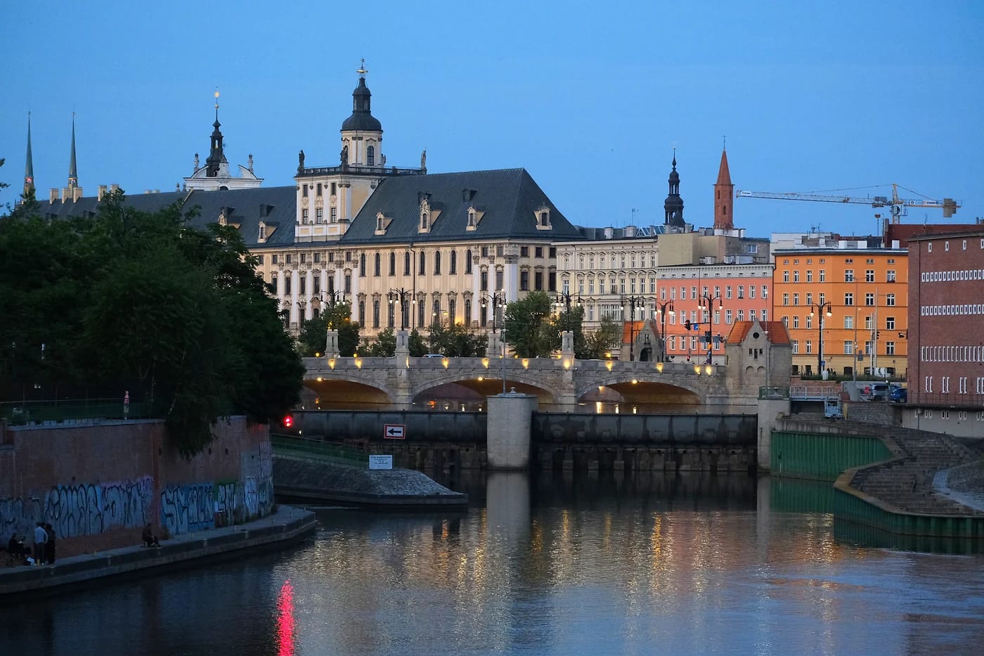 Wrocławin yliopisto Oderin rannalla hämärässä