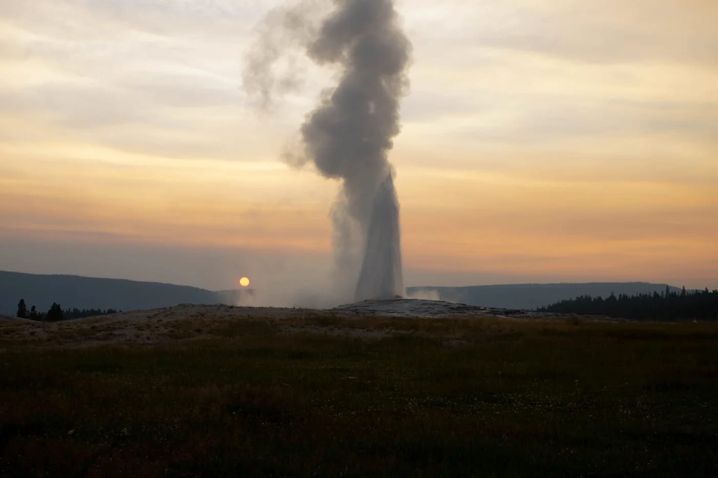 Old Faithful -geysirin purkaus auringonlaskussa