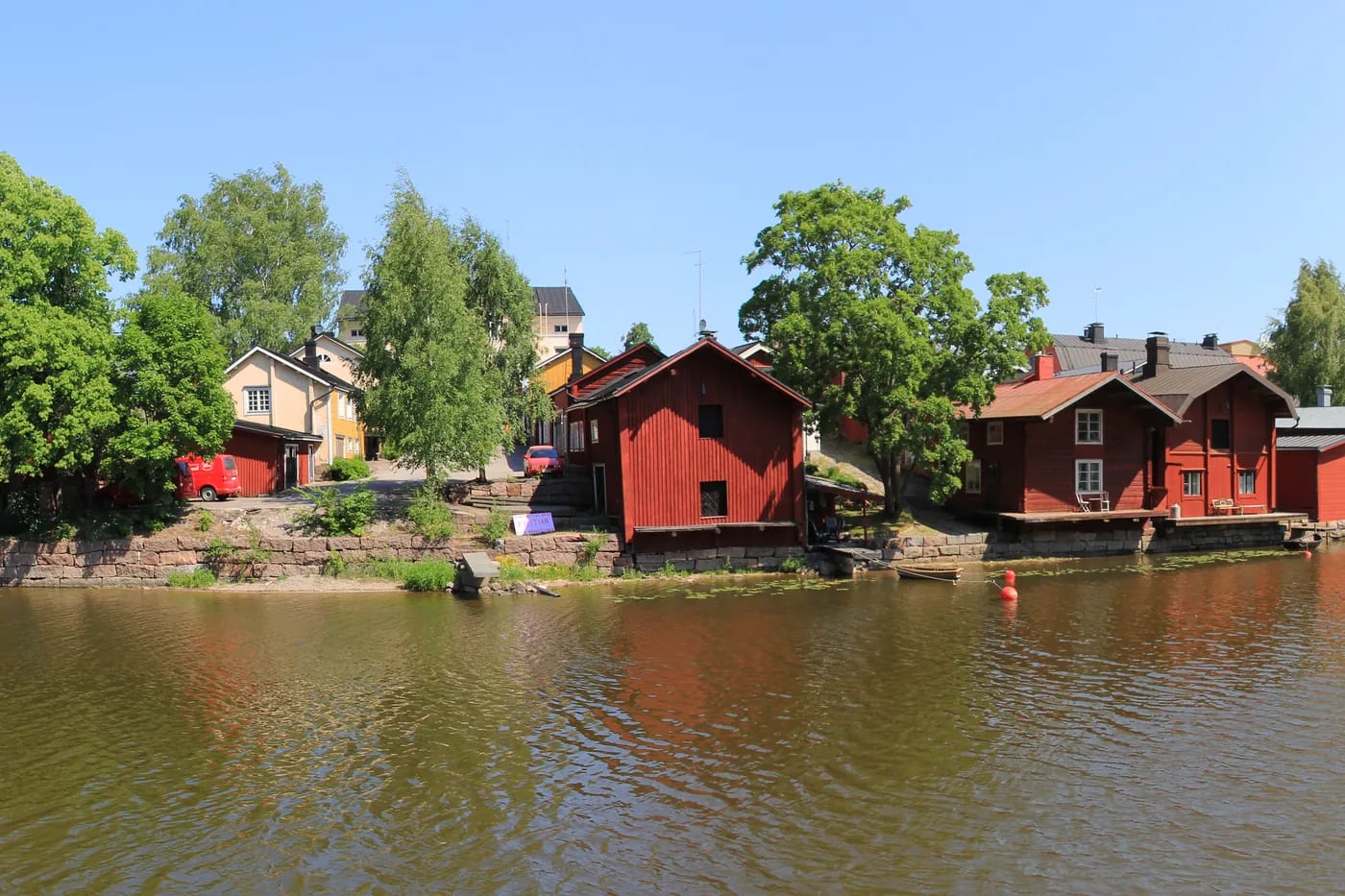 Ranta-aittojen rivi joen yli katsottuna